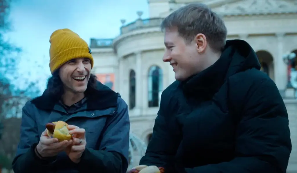 L'hacker Joe Grand, che indossa il berretto giallo, chiacchiera con il suo collega Bruno per le strade di Francoforte.